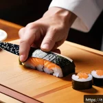 일본 스시 셰프 도구 - A professional sushi chef&rsquo;s workspace featuring a sharply honed Japanese stainless steel sushi knife...
